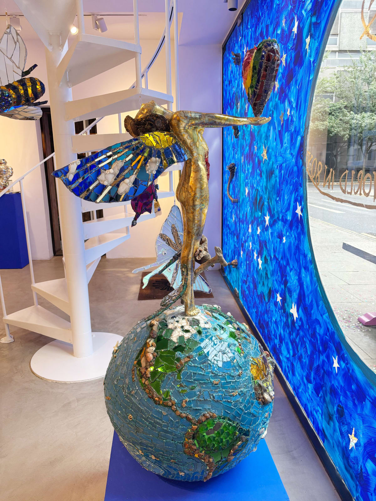 A colourful sculpture by Andrew Logan, celebrating life and the planet, in shimmering gold