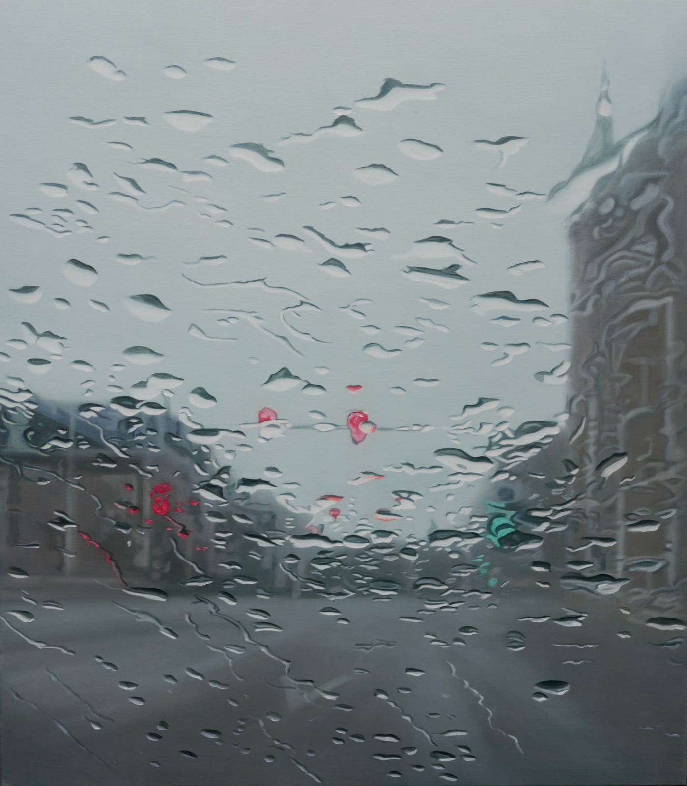 A road through town with buildings on either side and traffic lights above, seen through a glass screen with water droplets scattered across it. By artist Esther Nienhuis.