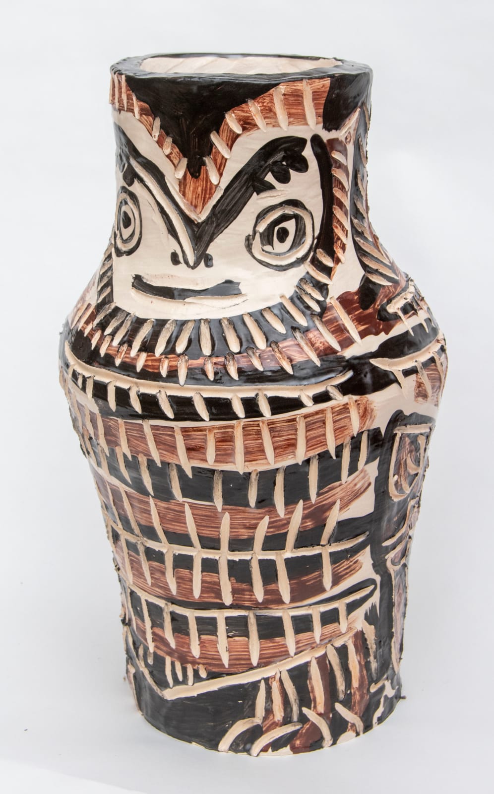 A sculpture of part of a totem with a face near the top and decorated with lots of black and brown segmented stripes by artist Reniel Del Rosario.