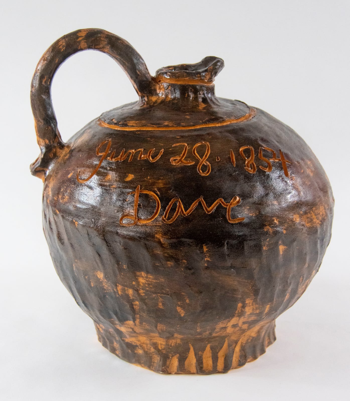A stoneware pot with the word Dave inscribed in the side by artist Reniel Del Rosario.