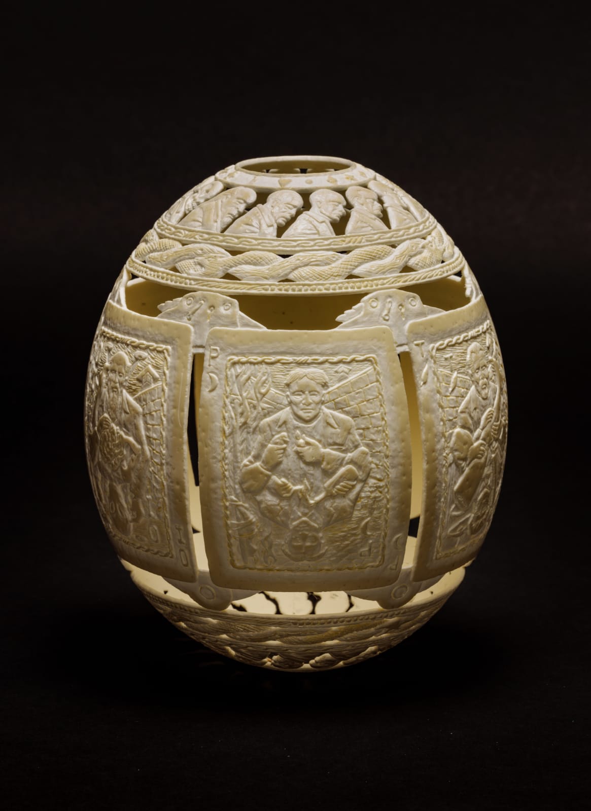 Intricately carved ostrich egg with depiction of playing cards with prisoners on them