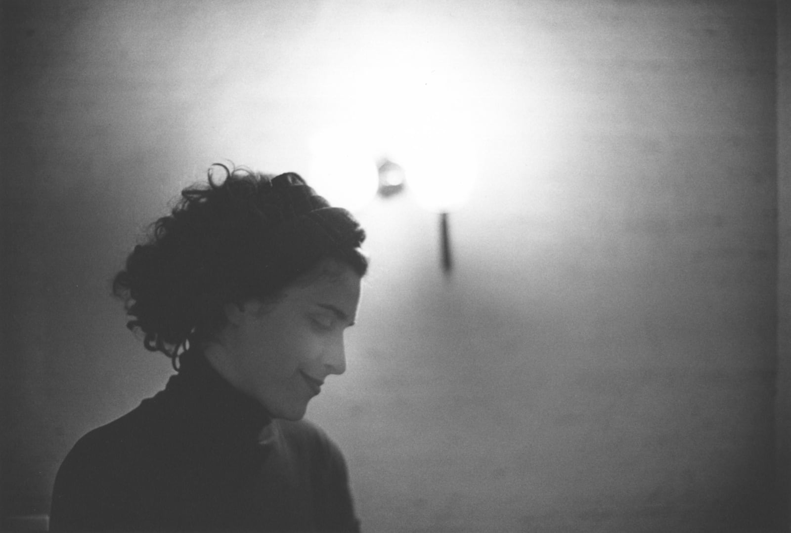 Tomio Seike, TSZ 202-6 Untitled - Paris, Zoe smiling profile against blank wall, 1984