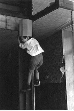 Helen Levitt, Untitled, New York (boy climbing pole with box on head), 1940