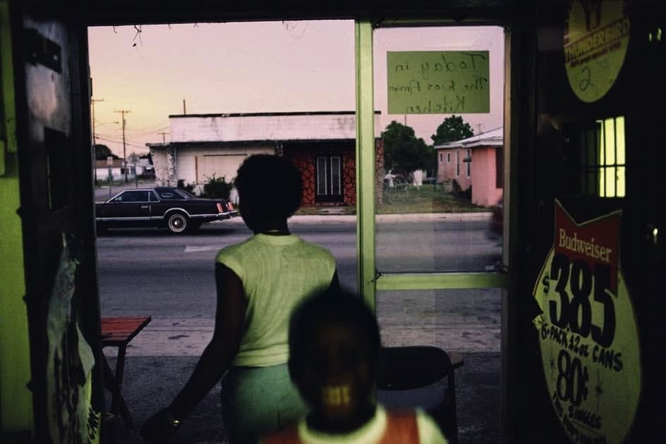 Alex Webb, Ft. Pierre (black woman looking out storefront), 1989