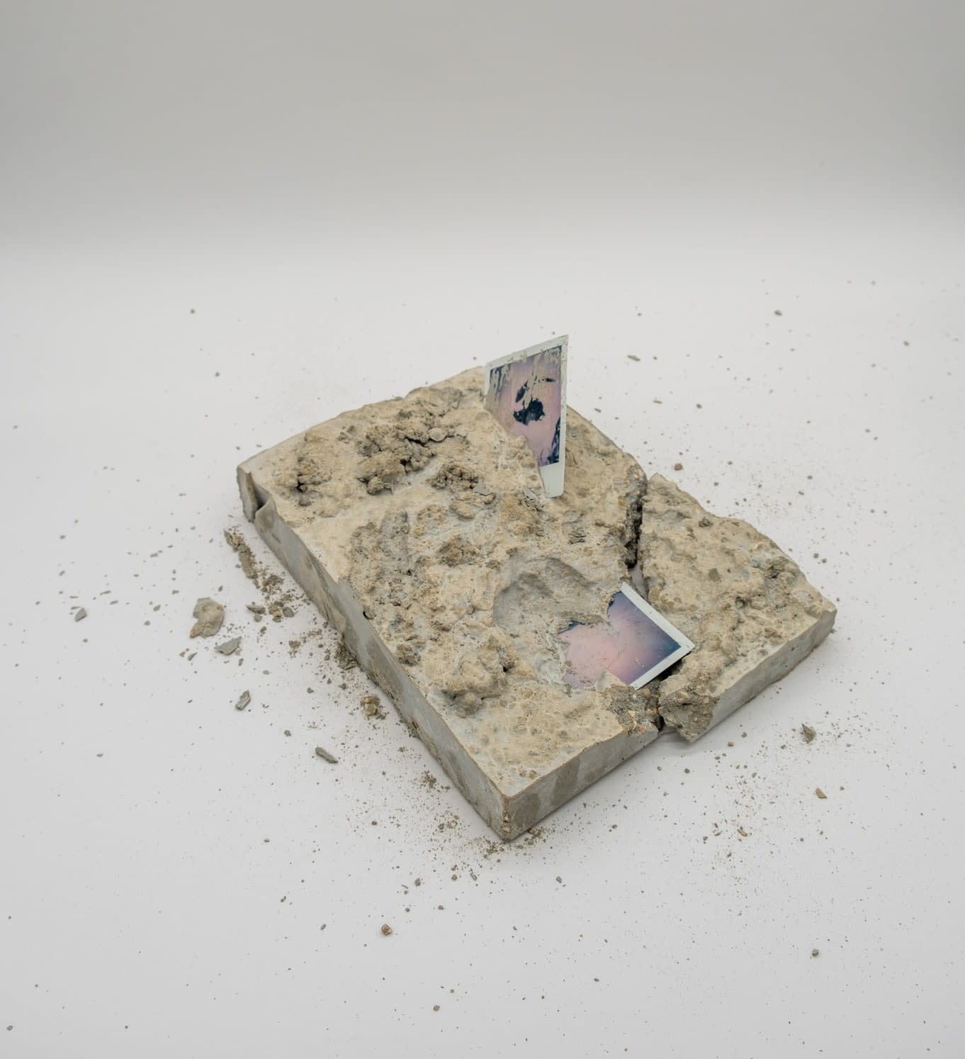 A sculpture by Shabez Jamal consisting of a photograph suspended in poured concrete that remains partially visible.