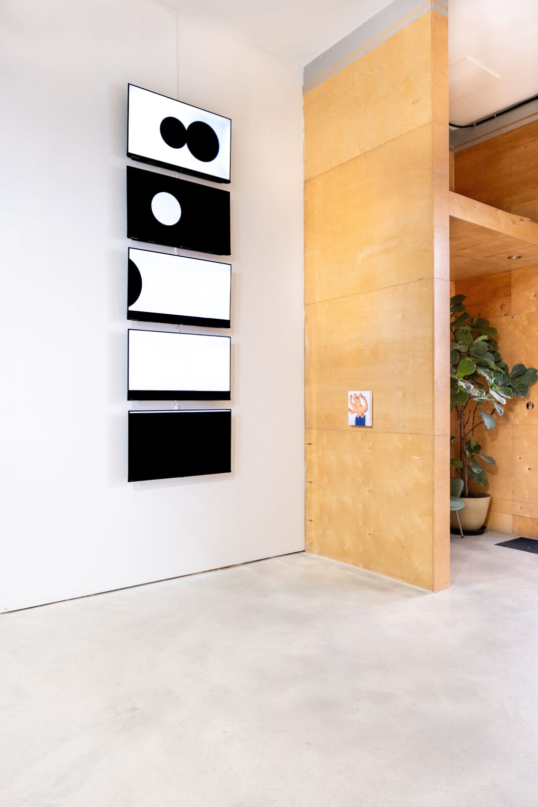 An installation view of a video simulation by Ian Gouldstone that features a multiple circles that move slowly around the screen, changing between black and white along with the moving background, at times overlapping to briefly reconcile into familiar shapes such as planets in eclipse.Frames from a video simulation by Ian Gouldstone that features a multiple circles that move slowly around the screen, changing between black and white along with the moving background, at times overlapping to briefly reconcile into familiar shapes such as planets in eclipse.