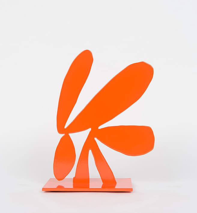 An orange abstract steel sculpture on an orange base.
