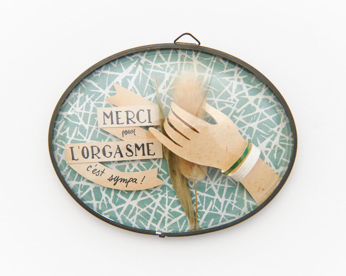 Petites Luxures multimedia piece featuring cutout of human hand holding for actual dried foxtail and French typography banner in oval frame
