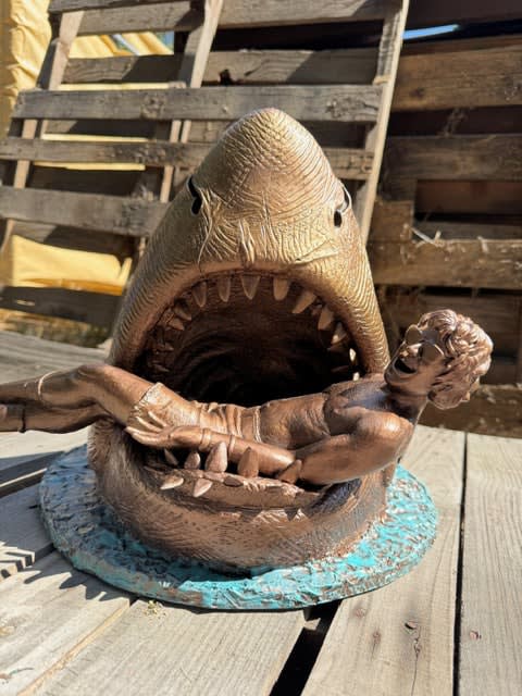 sculpture of a shark with a man in his mouth