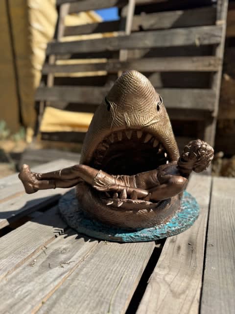 sculpture of a shark with a man in his mouth