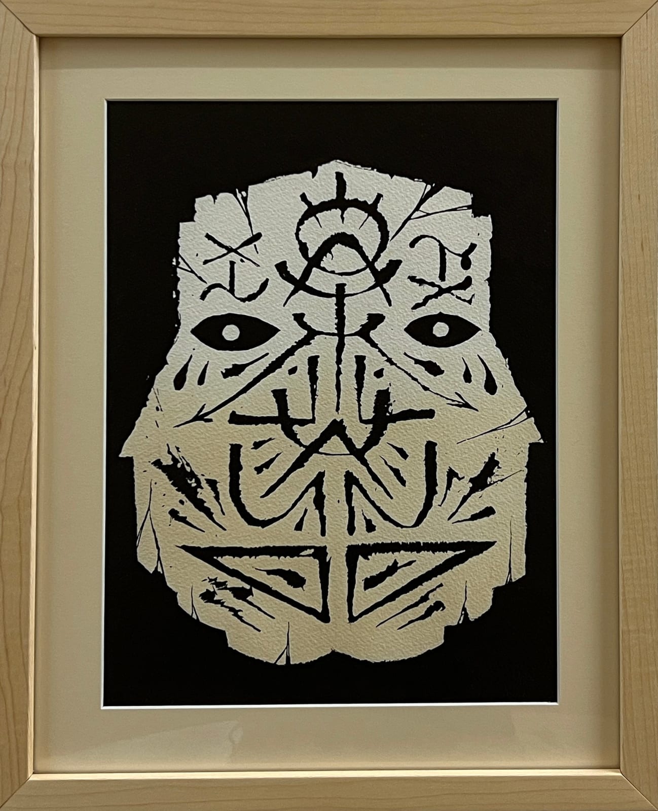 GATS drawing of a symbol covered mask over a black background