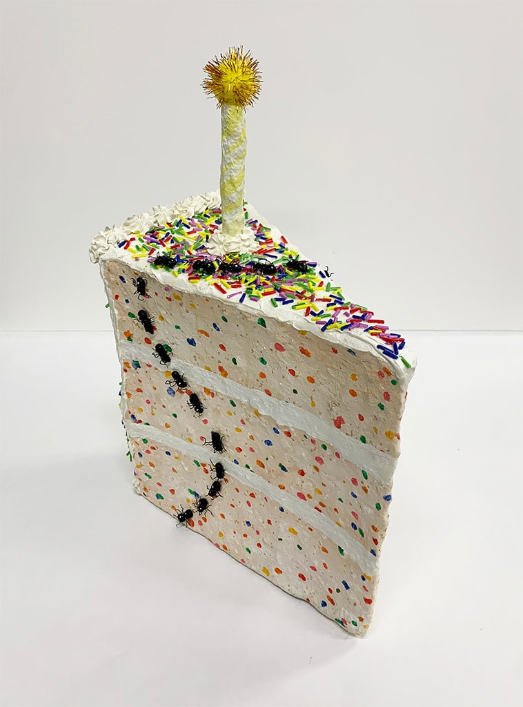 Nic Dyer mixed media sculpture of confetti cake slice with birthday candle, trail of ants on outside