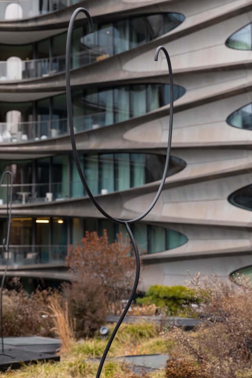 Tall wire sculpture with a bent semi circle on top