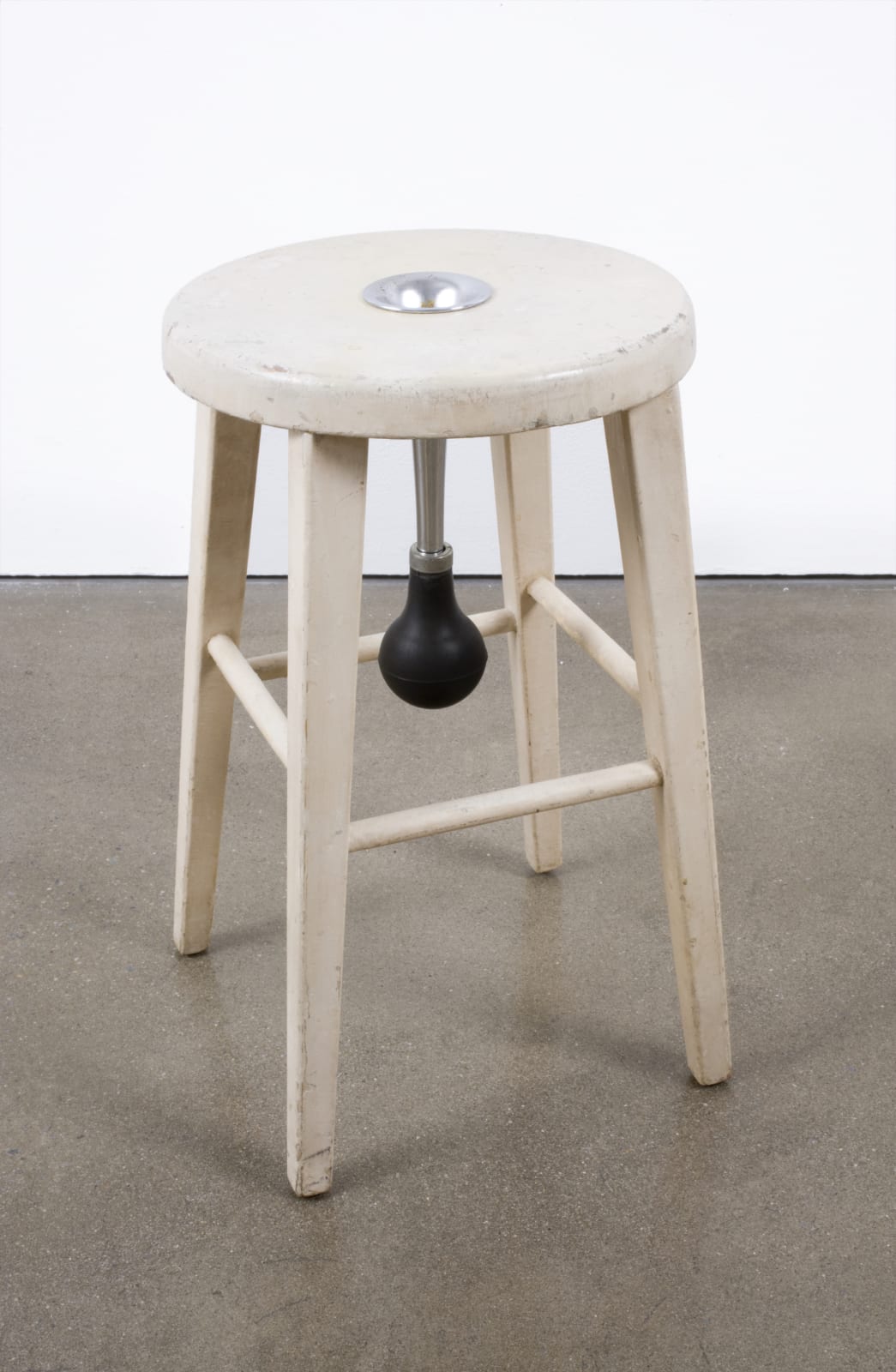A small wooden stool with a horn inserted in its center such that one can honk it through the stool's legs