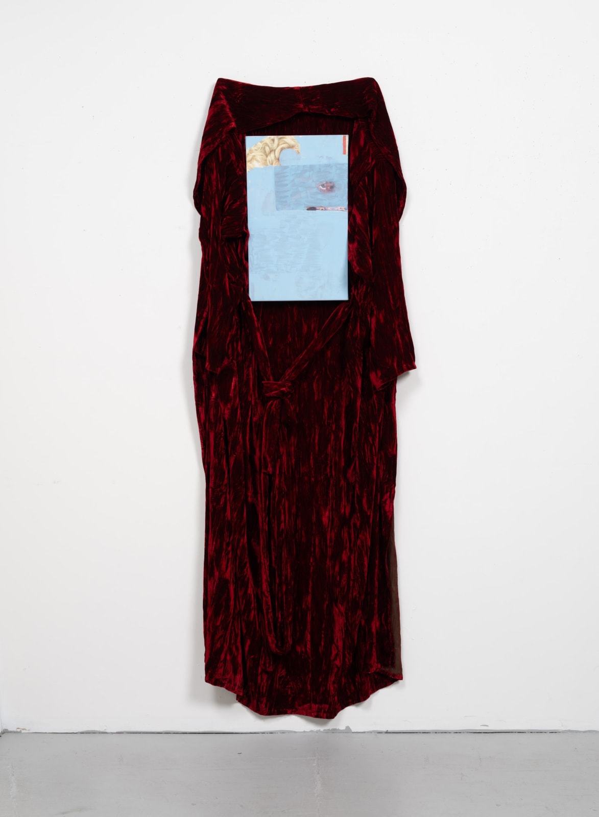 Red robe on wall with blue painting in the center