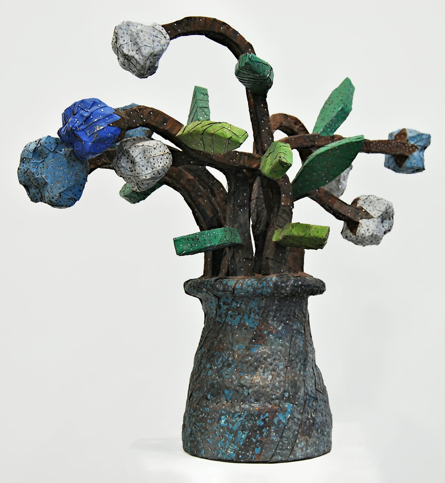 A vase of chunky flowers made from strips of colored tin