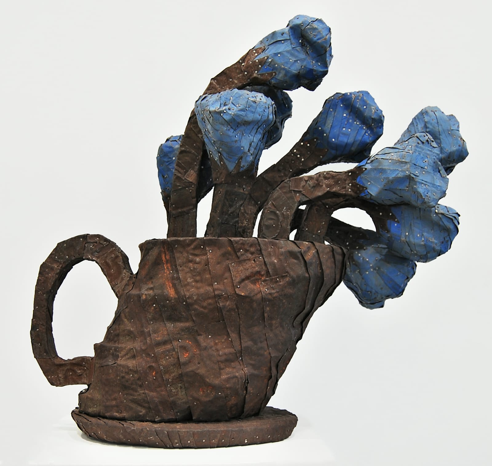 A vase of chunky flowers made from strips of colored tin