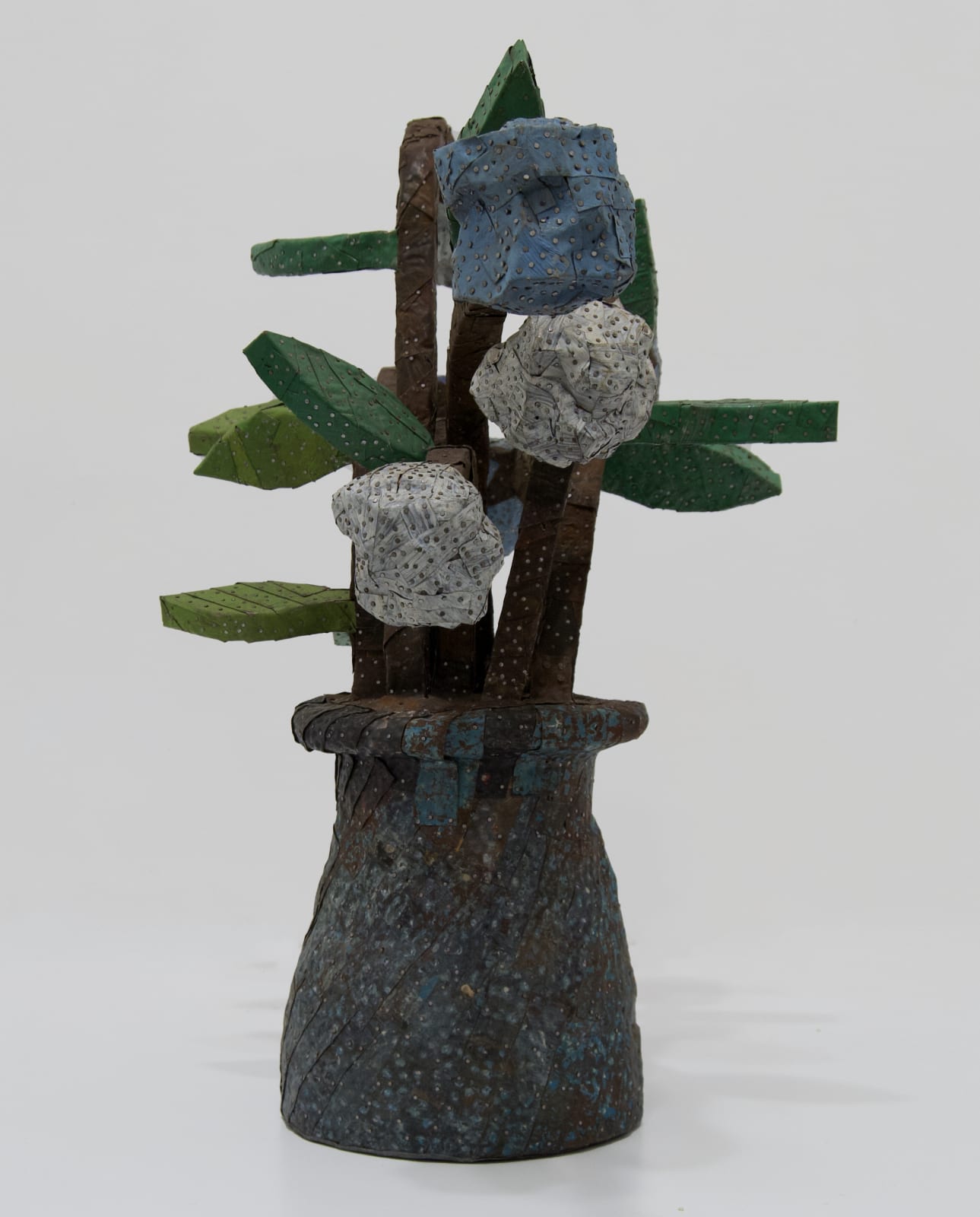 A vase of chunky flowers made from strips of colored tin