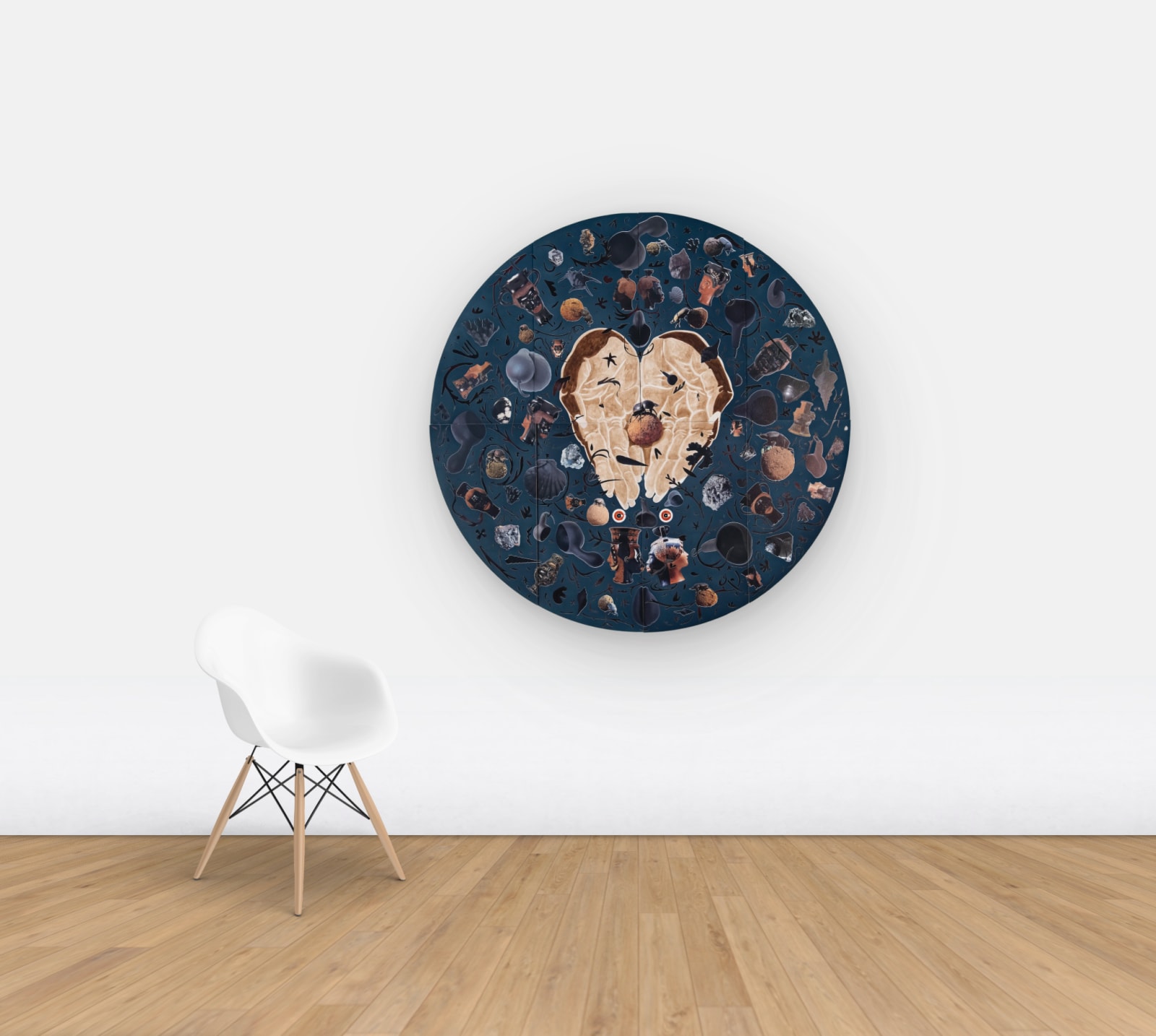 Blue velvet tondo with hands in the middle holding a dung beetle, surrounded by archeological objects hung on wall for scale