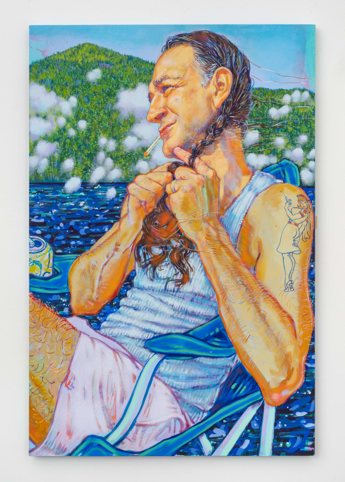 Man with long braid and nurse tattoo sitting dockside