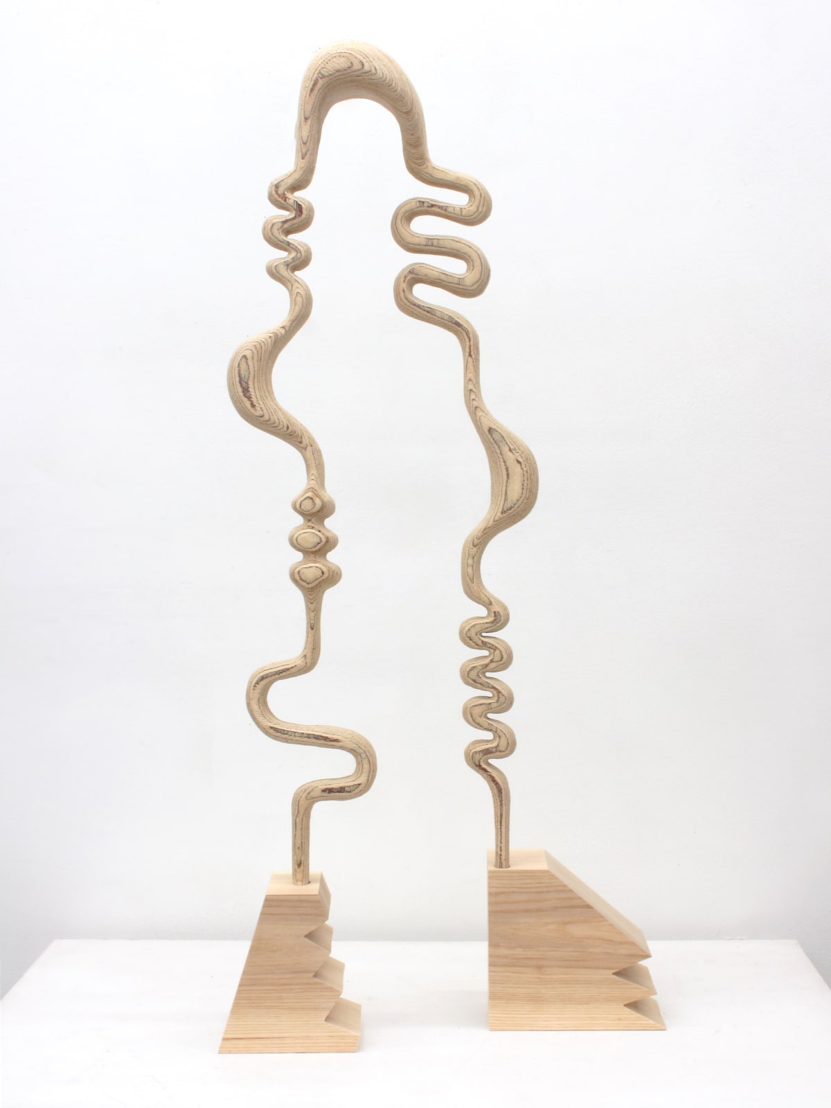 Abstract light wood sculpture with two feet and the profile of head and body