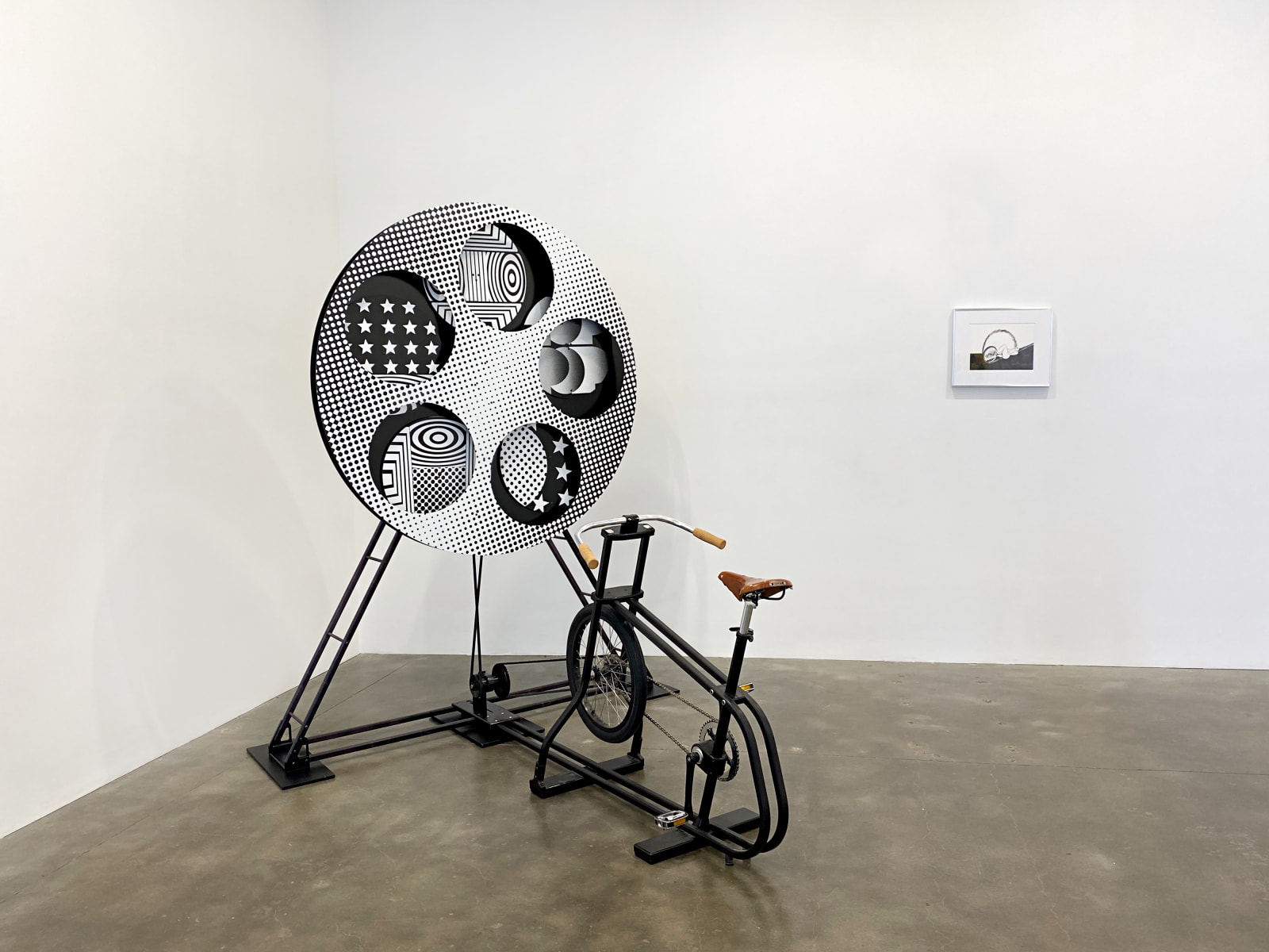 An interactive sculpture that uses a person on a bike to rotate a psychedelic-patterned disk