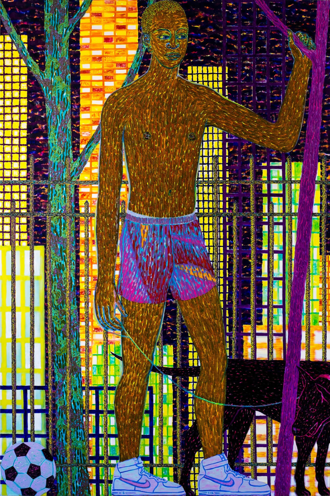 Man in shorts and nike sneakers stands with soccer ball next to him, behind his a night time cityscape