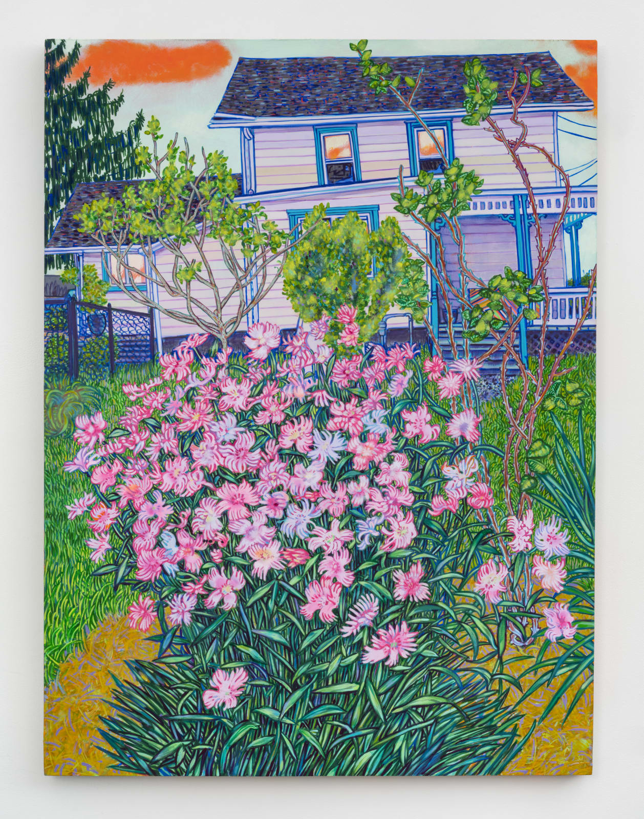 White house with pink flowered bush in foreground