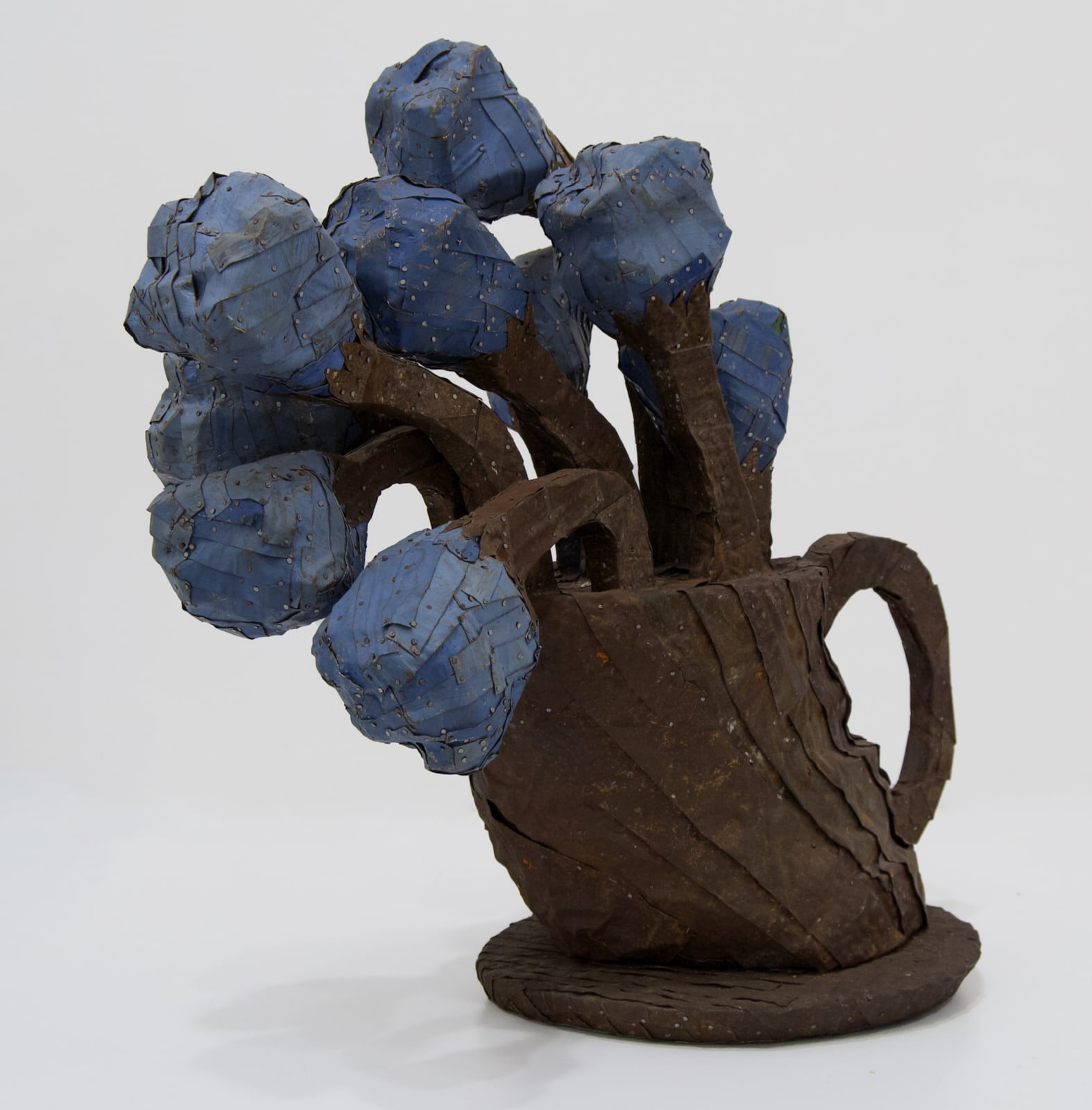 A vase of chunky flowers made from strips of colored tin