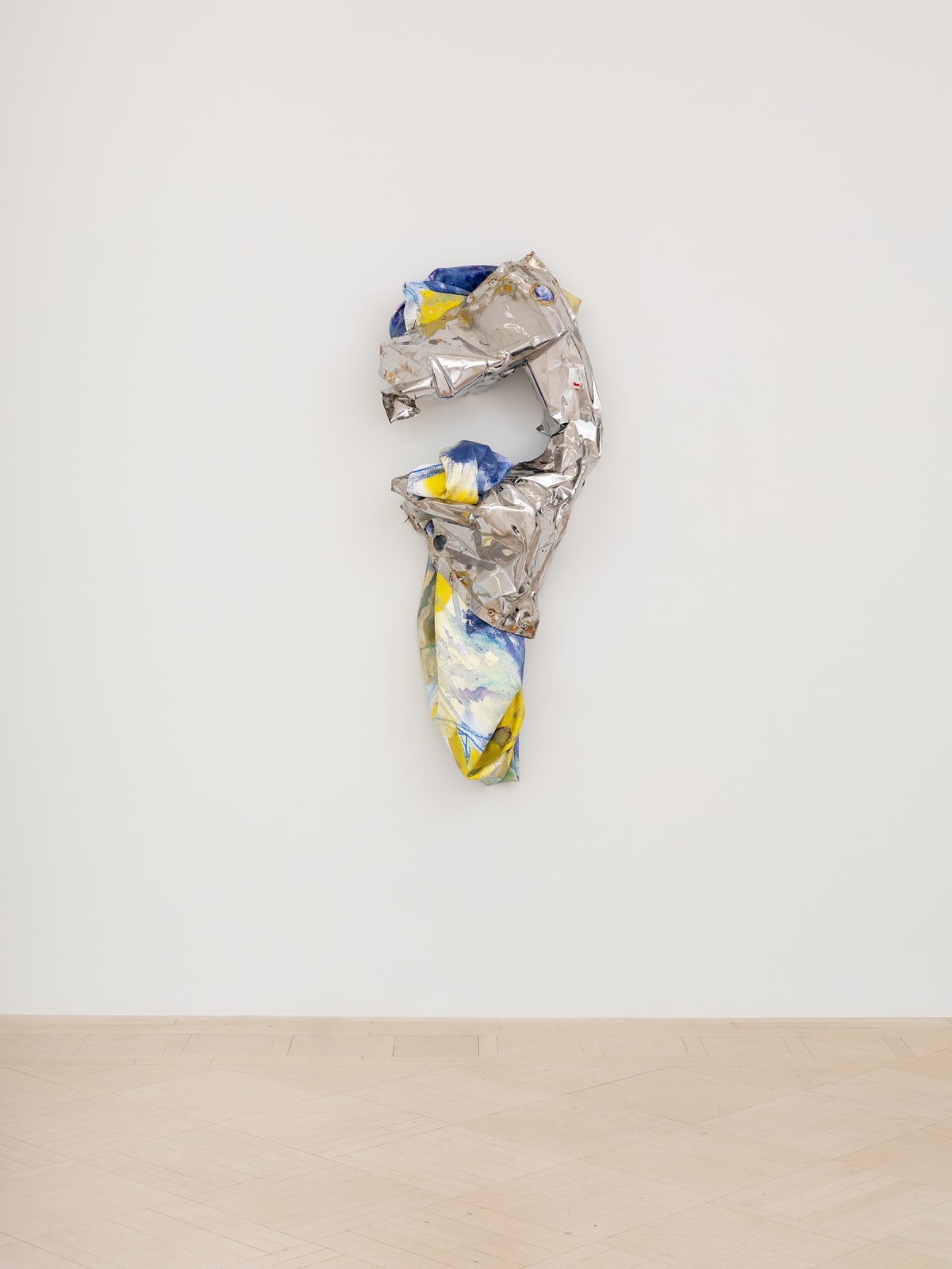 Hanging metal wall sculpture resembling a question mark