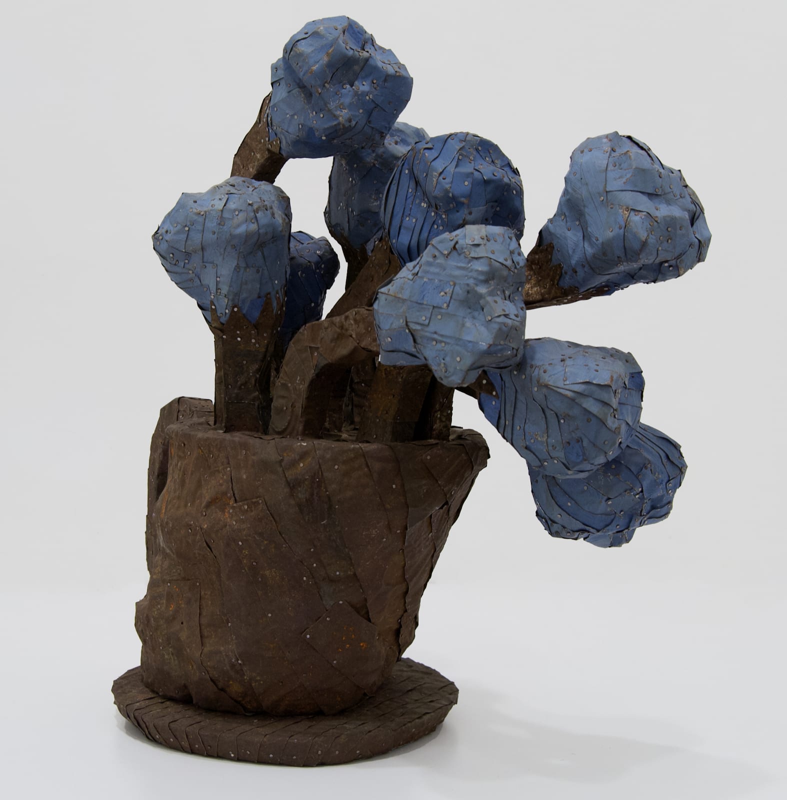 A vase of chunky flowers made from strips of colored tin