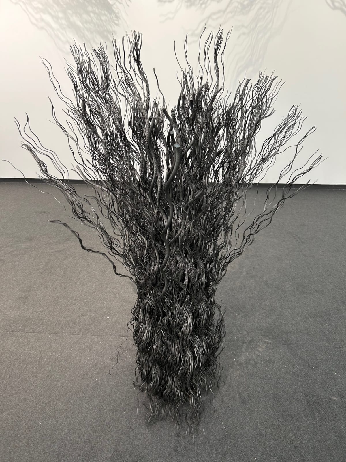 Wavy wire rope joined together to create a column unfurling at top