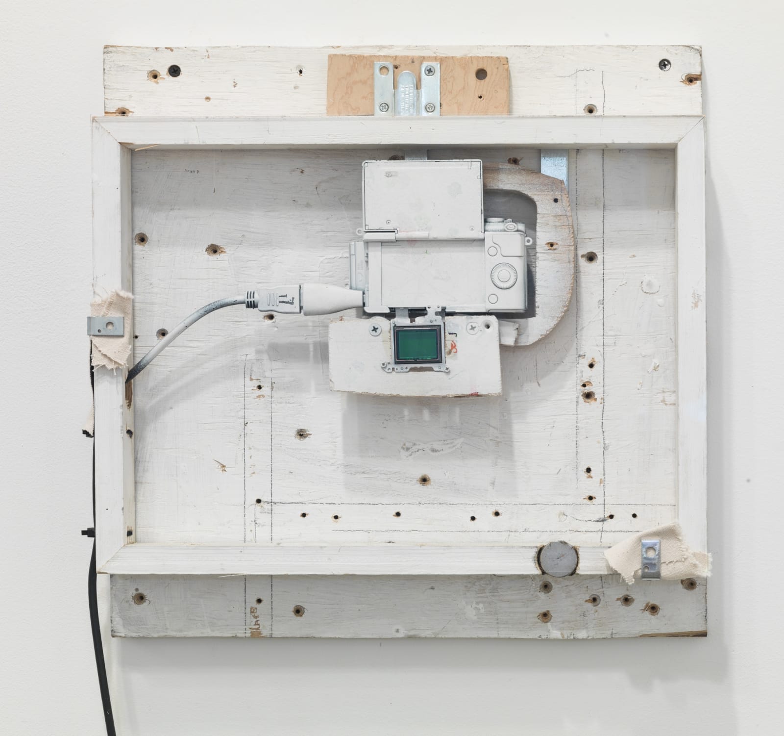 Abstract white rectangular sculpture with black wire coming out of the side