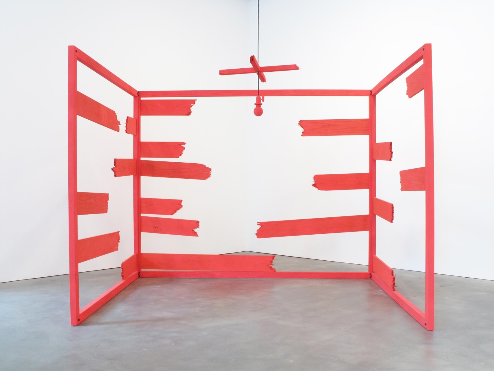 Large installation sculpture of three walls with a ceiling fan constructed from red painted oak