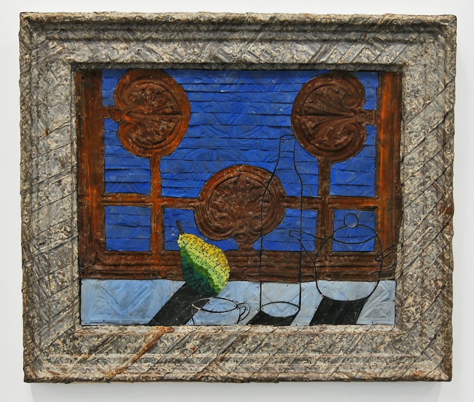 A still life surrounded by a heavy frame made from strips of colored tin