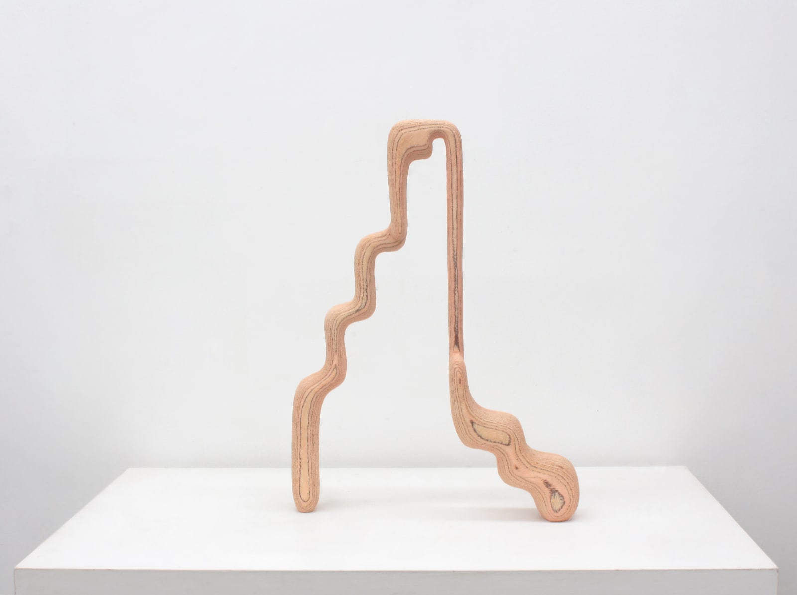 Carved light pink wood two legged sculpture, abstract