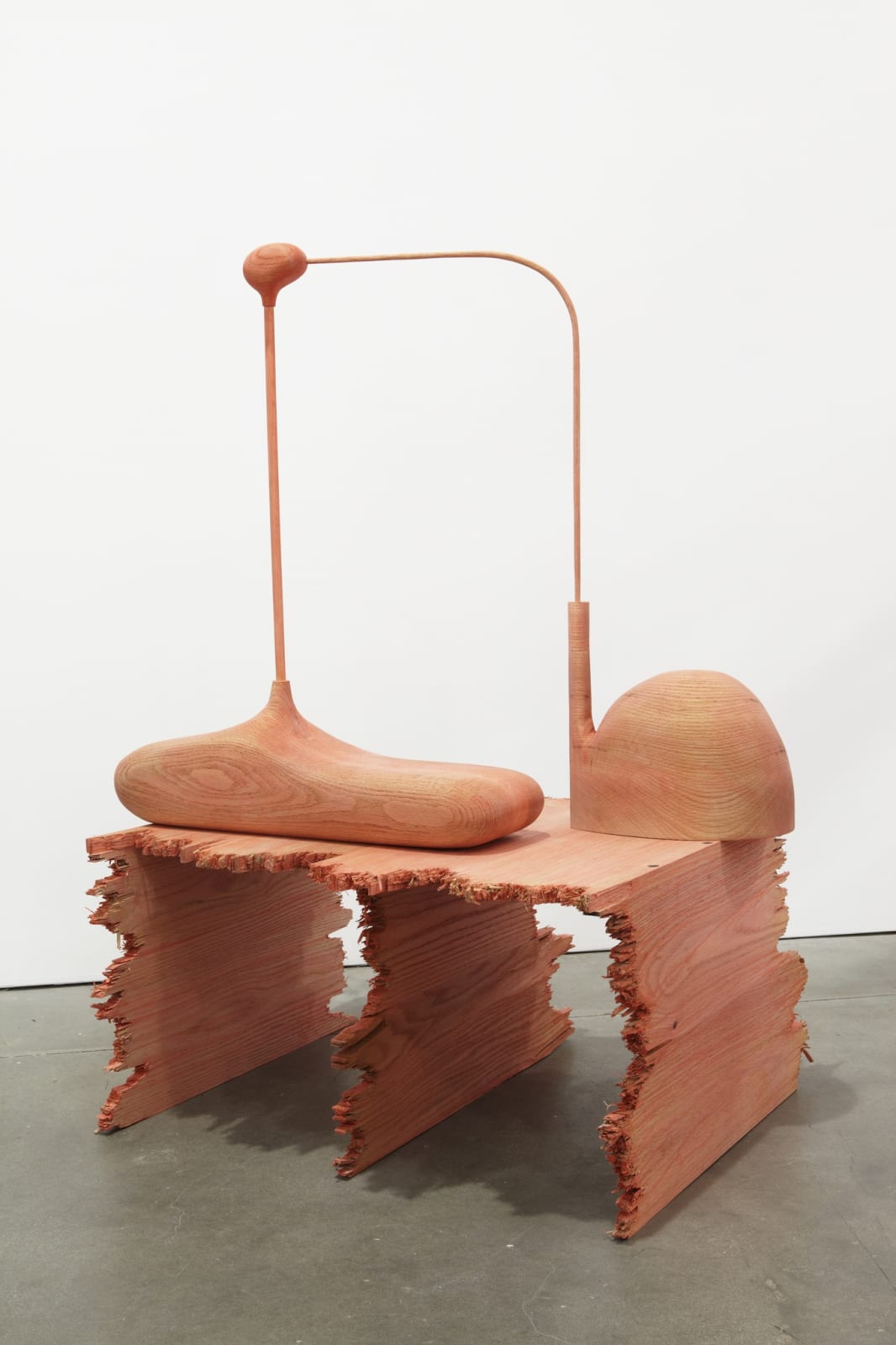Nude colored abstract sculpture of an abstract object sitting on a table-like platform