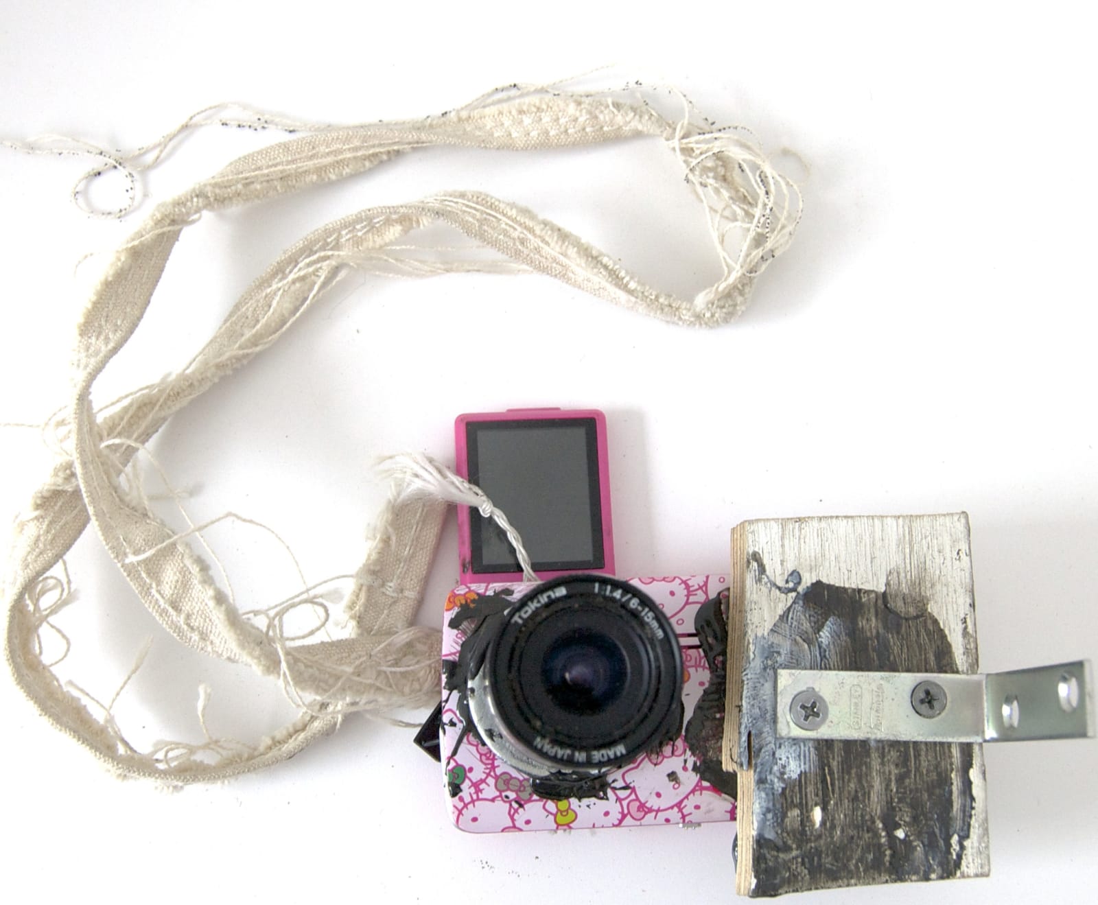 Sculpture created from canvas, digital camera parts, epoxy, graphite, hardware, lens, thread, wood installed on wall