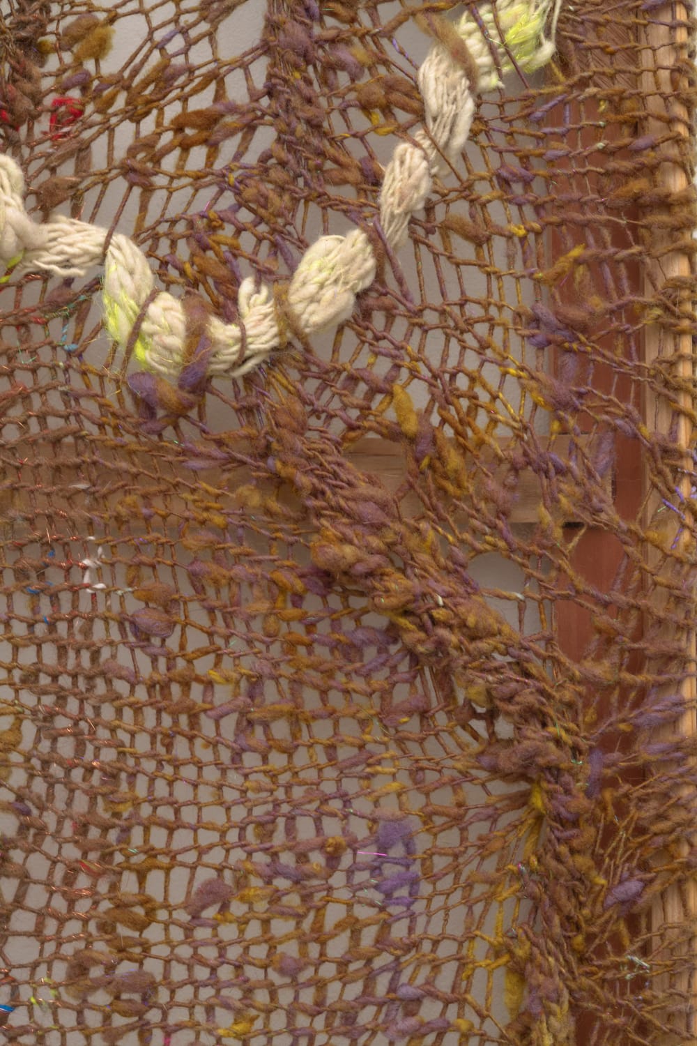 A cacophonous composition in multi-colored fibers stretched across a redwood frame as one would stretch a painting. The fibers are knit at varying thicknesses so that in places one can see through the stitches to the wall behind. The composition has a wave-like pattern with many fractal fields of varying colors.
