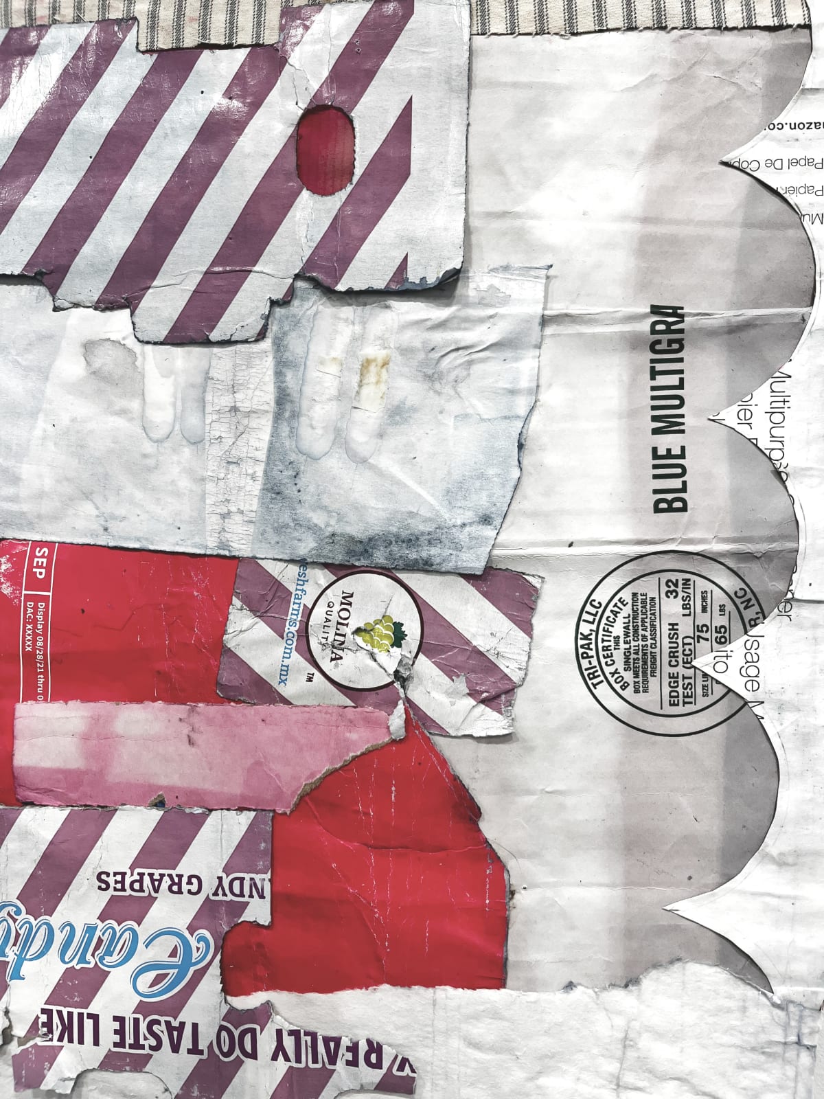 Close-up of cardboard assemblage that resembles an abstract quilt with stripes and irregular pieces
