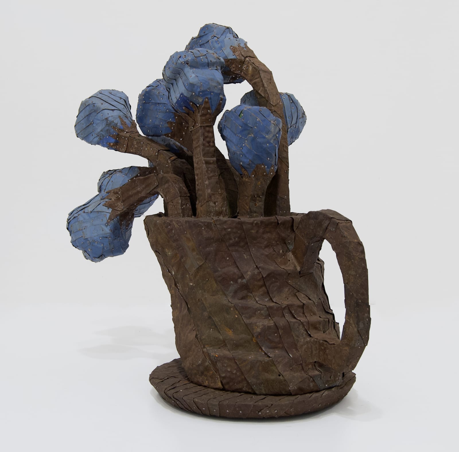 A vase of chunky flowers made from strips of colored tin