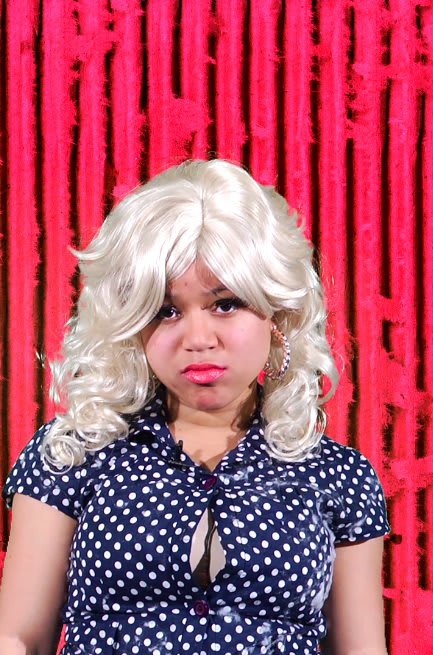 Woman wearing blonde wig and polka dot blouse