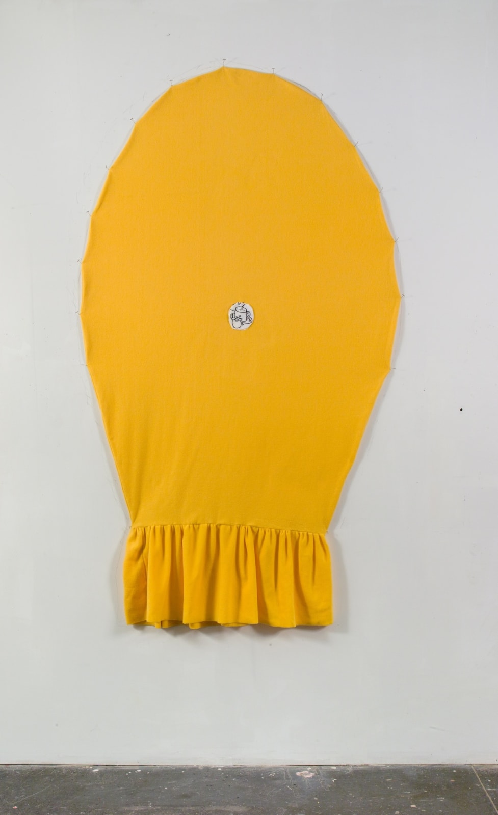 Bright yellow balloon shaped fabric work with black and white line drawing of fruit bowl stitched in center