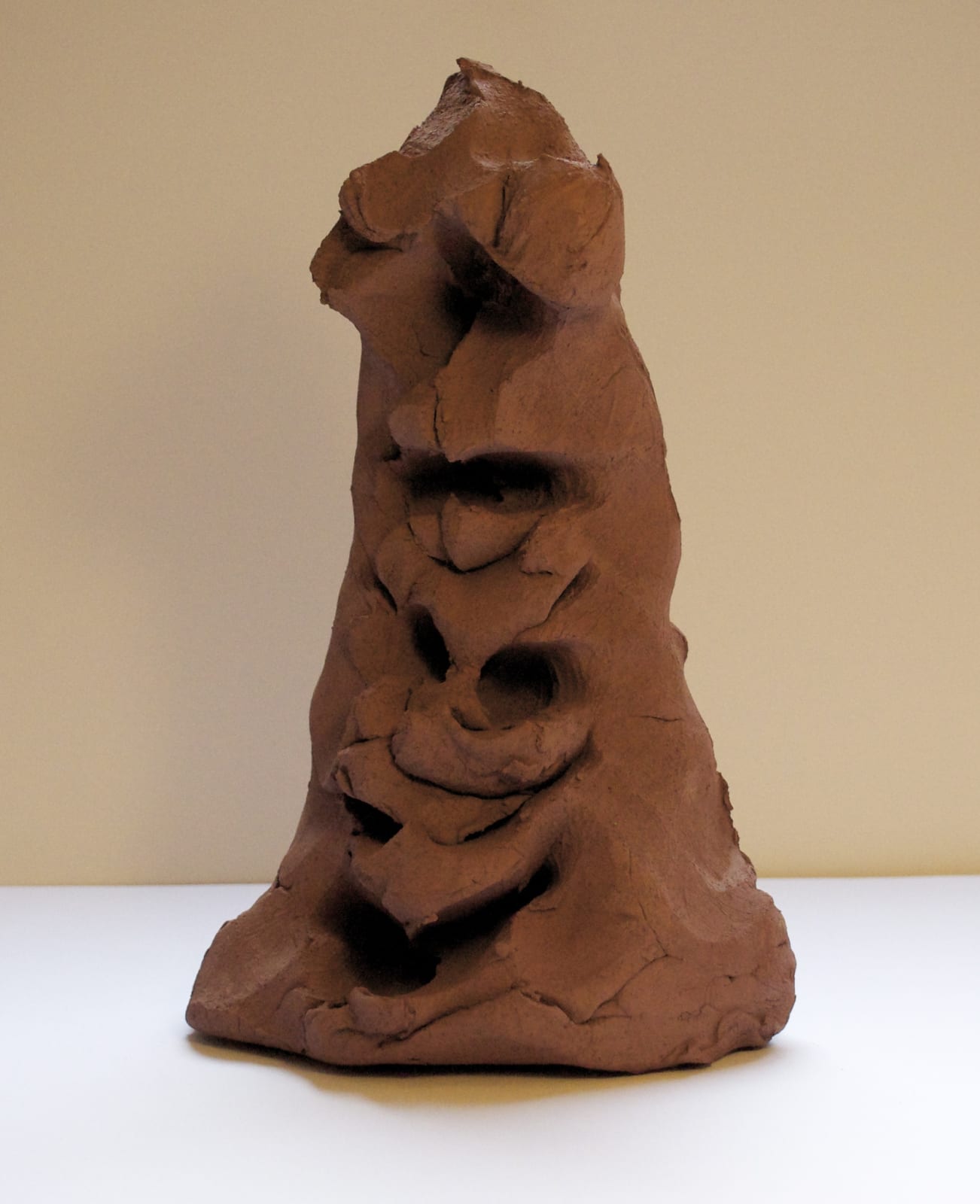 Terracotta sculpture in a triangular shape with faces in it