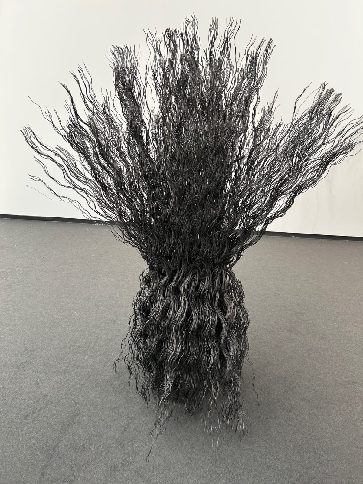 Wavy wire rope joined together to create a column unfurling at top