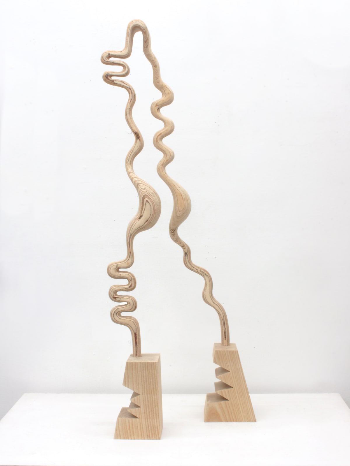 Abstract light wood sculpture with two feet and the profile of head and body