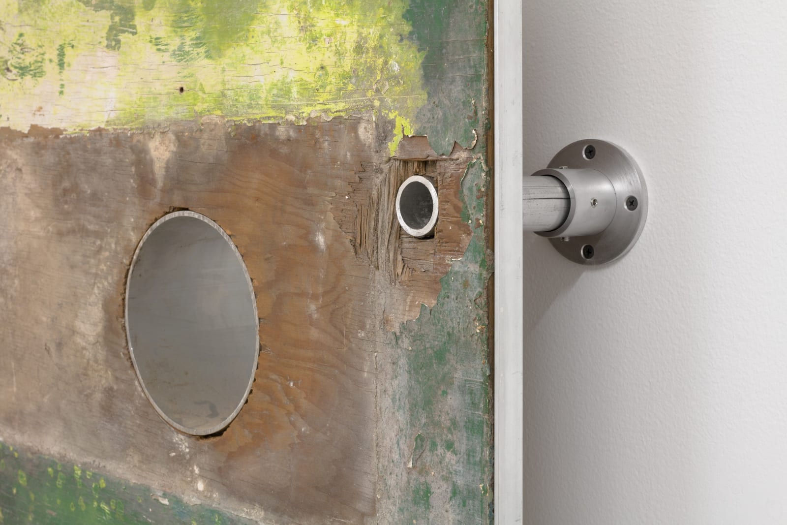 Karyn Olivier's sculpture, a photographic print mounted on the wall with metal pipes, on the floor is a large coconut husk log