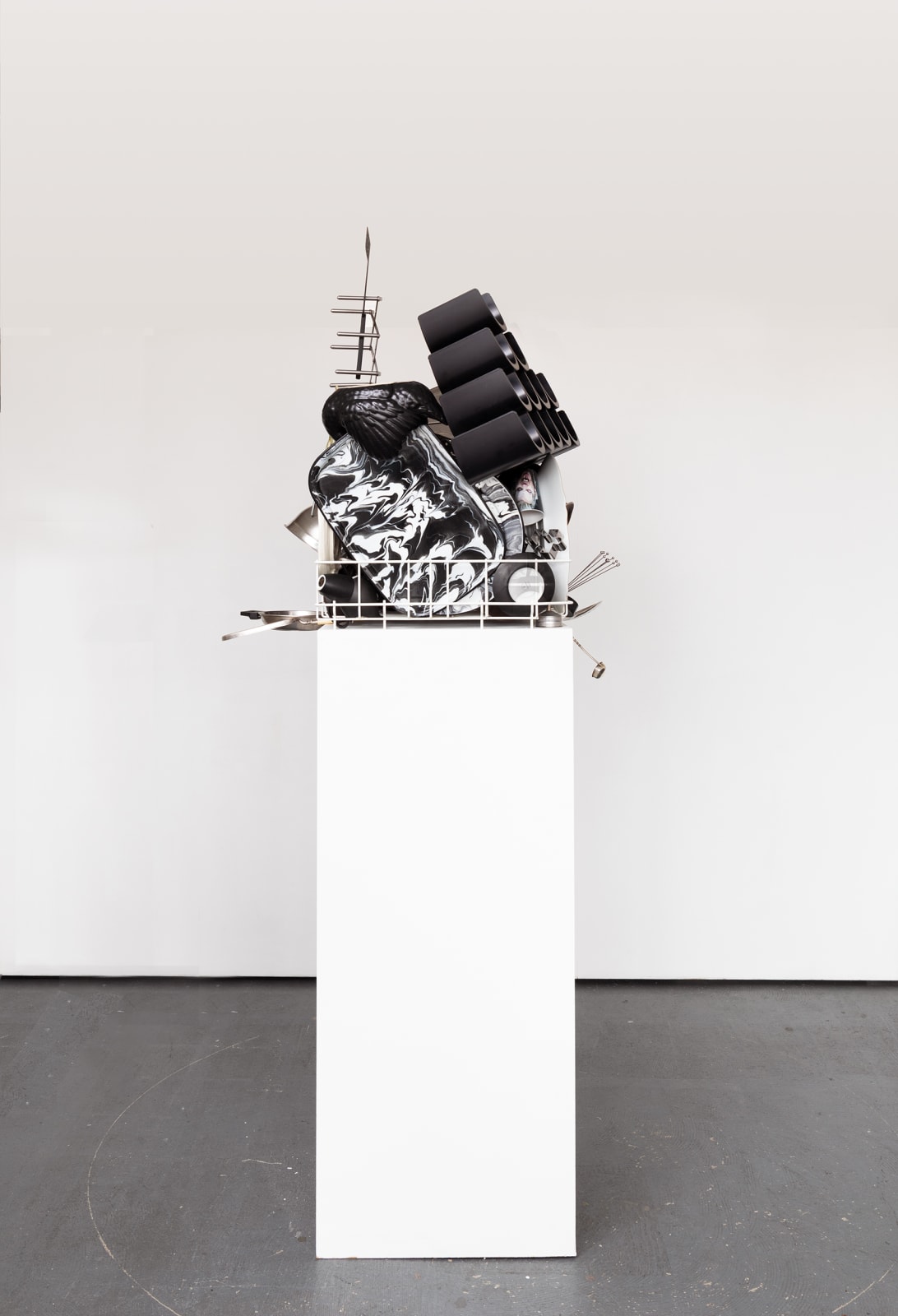Sculpture with various china, ceramic, kitchen utensils and modified dishwasher on pedestal