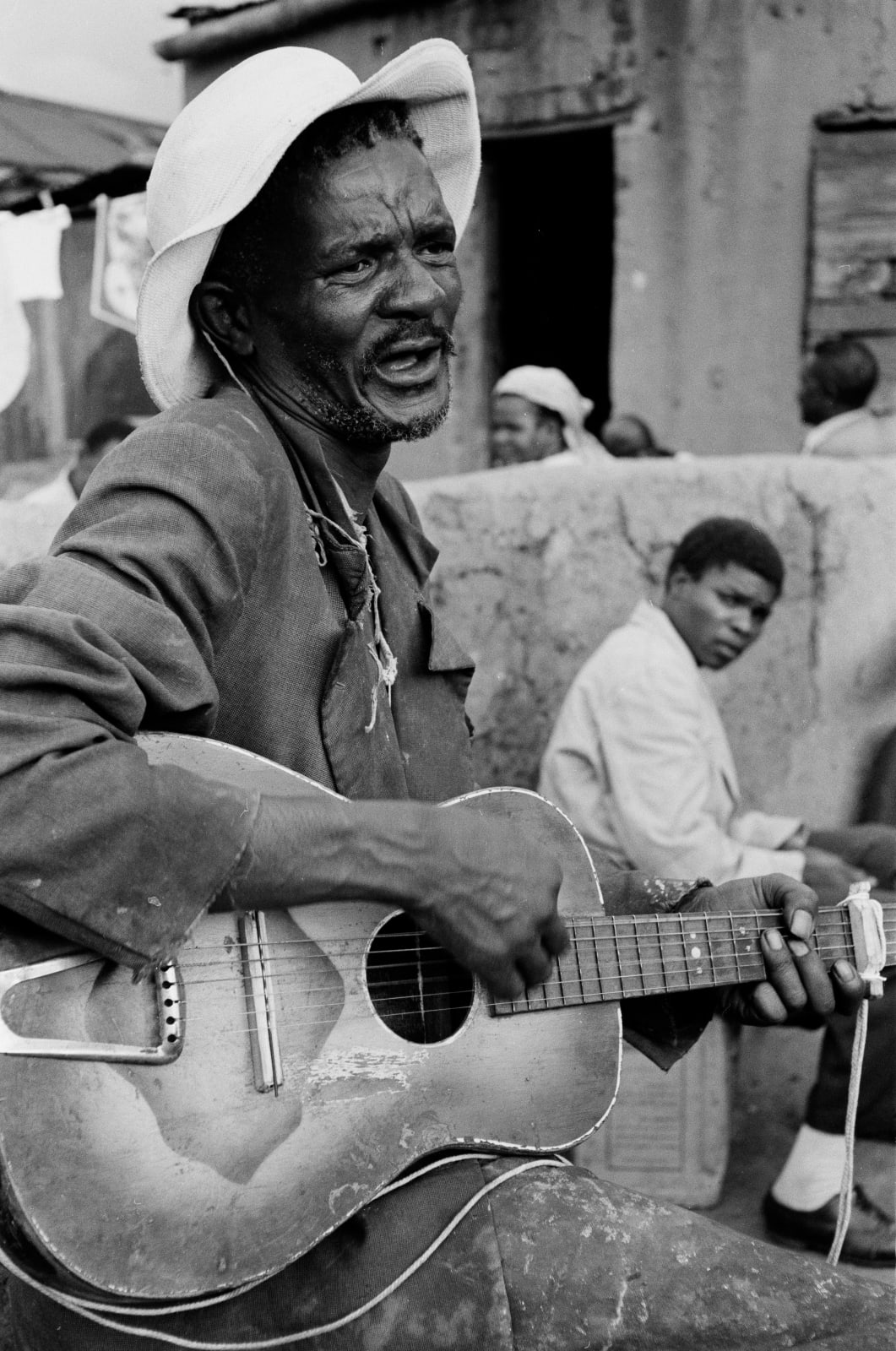 Ernest Cole, Man playing guitar in shebeen, circa 1965