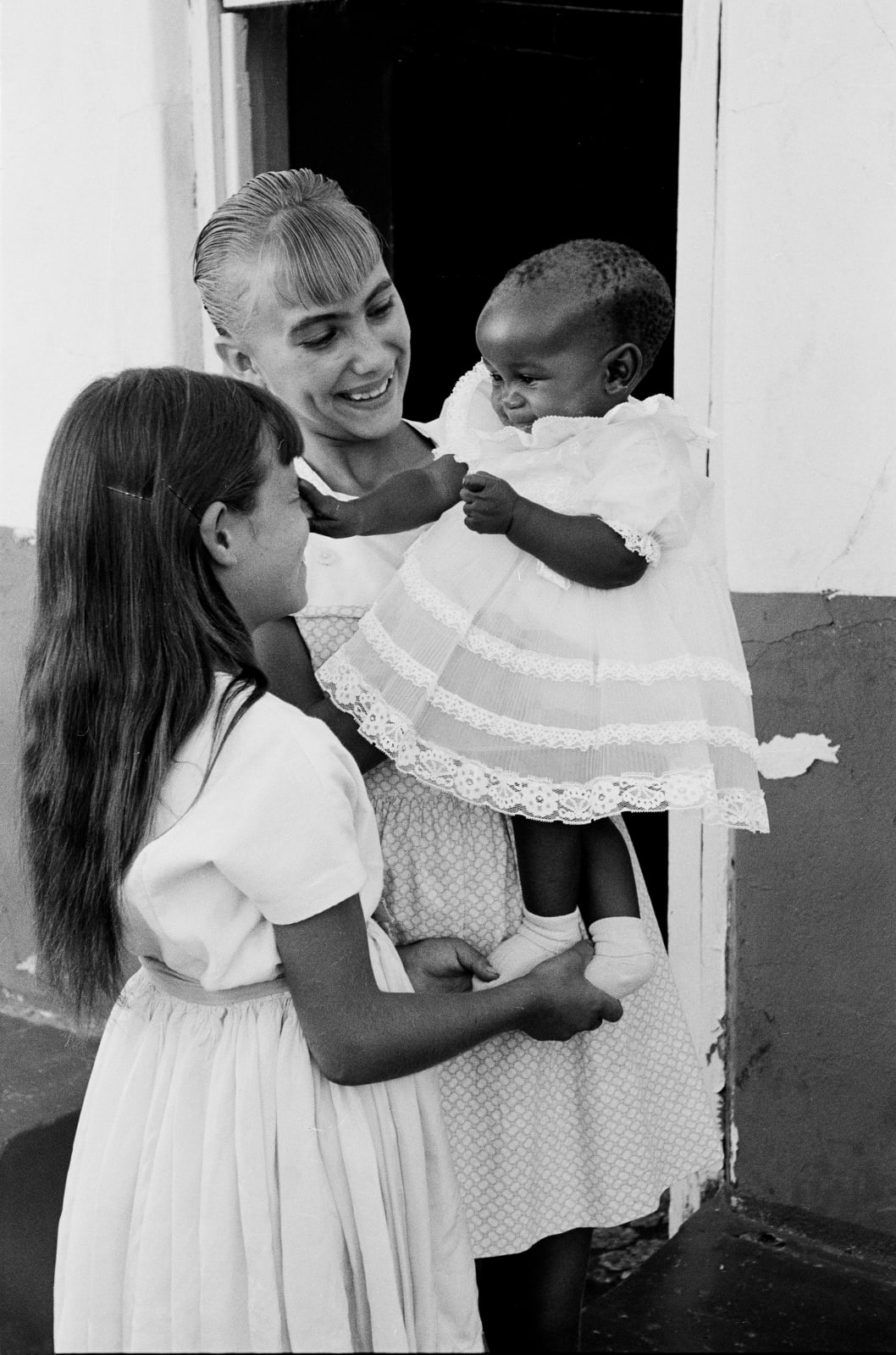 Ernest Cole, Young white woman holds black baby , circa 1965